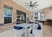 Thumbnail 38 of 55 - A patio with a table and chairs is surrounded by brick walls.