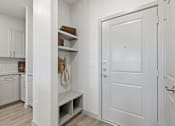 Thumbnail 33 of 55 - A white door is in a white room with a white cabinet and a white bench.