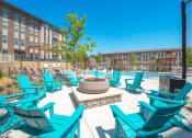 Thumbnail 28 of 35 - a patio with blue chairs and a fire pit