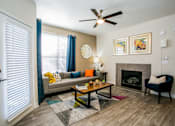 Thumbnail 4 of 44 - A living room with a fireplace and a couch.