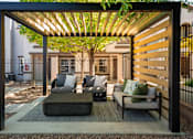 Thumbnail 17 of 38 - a patio with couches and chairs under a wooden pergola