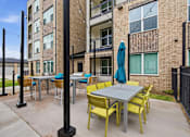 Thumbnail 39 of 55 - A patio with a table and chairs is surrounded by a black fence.