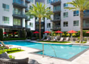 Thumbnail 8 of 48 - a swimming pool in front of an apartment building at VORA LUX, San Diego California