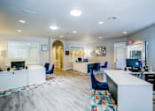Thumbnail 44 of 44 - A spacious office with a white reception desk and blue chairs.