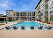 Thumbnail 7 of 55 - A swimming pool in front of apartment buildings.