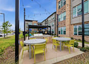 Thumbnail 17 of 55 - A patio with a table and chairs is surrounded by a brick building.