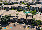 Thumbnail 45 of 48 - A view of apartment buildings with a pool and palm trees.
