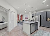 Thumbnail 19 of 20 - A modern kitchen with a large island and a dining area.