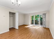 Thumbnail 22 of 33 - Spacious bedroom with patio access and wood flooring at Hubbard's Crossing Apartments, Kirkland, WA