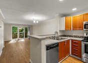 Thumbnail 26 of 33 - Open kitchen with breakfast bar and wood flooring at Hubbard's Crossing Apartments, Washington