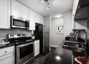 Thumbnail 11 of 22 - a kitchen with a stove top oven next to a sink