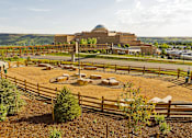 Thumbnail 20 of 28 - A large building with a dome on top is surrounded by a wooden fence and has a circular area in front of it.