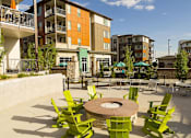 Thumbnail 19 of 28 - Green chairs are arranged around a circular table in the middle of a patio.