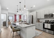Thumbnail 22 of 55 - A modern kitchen with a large island and stainless steel appliances.