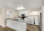 Thumbnail 5 of 30 - A kitchen with white cabinets and appliances.