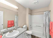 Thumbnail 11 of 30 - A bathroom with a toilet, sink, and shower.