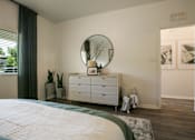 Thumbnail 22 of 38 - a bedroom with a bed and a dresser with a mirror