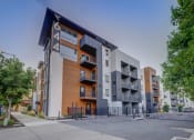Thumbnail 1 of 25 - modern apartment building with a sidewalk in front of it