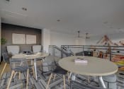 Thumbnail 16 of 25 - clubhouse loft area with tables and chairs and a staircase
