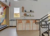 Thumbnail 14 of 25 - clubroom kitchen with bar stools and a staircase