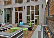 Thumbnail 6 of 13 - A modern outdoor seating area with a fire feature.