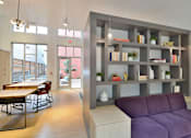 Thumbnail 8 of 13 - A modern living room with a purple couch and a grey bookshelf.