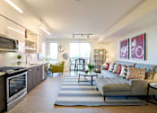 Thumbnail 13 of 13 - A modern kitchen with a large island and a living room with a couch.