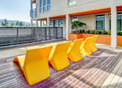Thumbnail 11 of 13 - A row of yellow chairs are lined up on a brick patio.