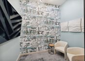 Thumbnail 26 of 30 - a room with two chairs and a wall with a mural of a city