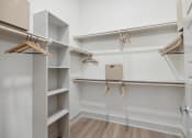 Thumbnail 15 of 30 - a spacious walk in closet with shelves and hangers