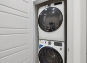 Thumbnail 16 of 30 - a front loading washer and dryer in a laundry room
