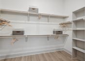 Thumbnail 4 of 30 - a walk in closet with shelves and hooks and baskets