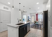 Thumbnail 32 of 55 - A modern kitchen with a white countertop and black cabinets.
