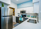 Thumbnail 7 of 44 - A kitchen with a stainless steel refrigerator and a sink.