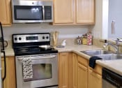 Thumbnail 22 of 37 - a kitchen with wooden cabinets and stainless steel appliances