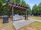 Thumbnail 22 of 48 - A wooden structure with a metal gate and a signboard in front of a fence.