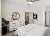 Thumbnail 22 of 29 - a white bedroom with a white bed and a ceiling fan