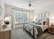Thumbnail 23 of 29 - a bedroom with a bed and a ceiling fan