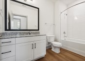 Thumbnail 25 of 29 - a bathroom with white cabinets and a large mirror and a white toilet and shower