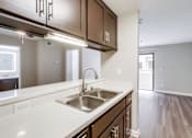 Thumbnail 3 of 51 - A kitchen with a sink and brown cabinets.