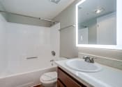 Thumbnail 16 of 51 - A white toilet sits next to a white sink in a bathroom.