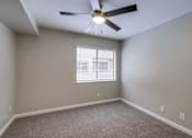 Thumbnail 12 of 51 - A room with a ceiling fan and a window with blinds.