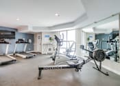Thumbnail 20 of 51 - A gym with treadmills, elliptical machines, and a stationary bike.