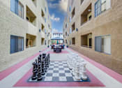 Thumbnail 28 of 51 - A giant chess board is set up in the courtyard of a building.