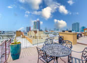 Thumbnail 25 of 51 - A table and chairs set on a balcony with a view of the city.
