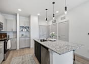 Thumbnail 36 of 55 - A kitchen with a granite countertop and white cabinets.