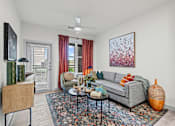 Thumbnail 1 of 20 - A living room with a grey couch, a coffee table, and a painting on the wall.