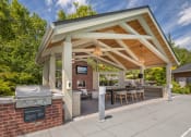 Thumbnail 27 of 38 - a covered patio with a grill and a table and chairs at Arbor Heights, Tigard, 97224