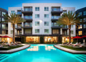 Thumbnail 3 of 48 - a swimming pool in front of Vora Mission Valley Apartments at night at VORA LUX, San Diego