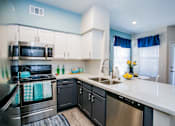 Thumbnail 9 of 44 - A kitchen with a stove, oven, microwave, and dishwasher.